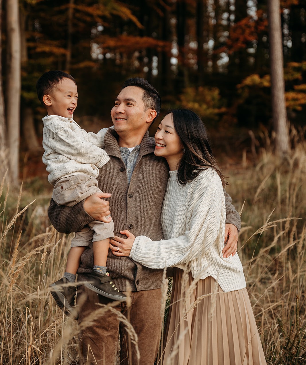 Eltern mit Kleinkind beim Familien-Foto-Shooting im herbstlichen Wald